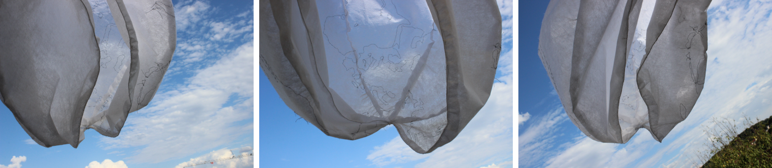 Drei Varianten der Erdhülle aus durchsichtig-weißem Vlies von Innen vor blau-wolkigem Himmel